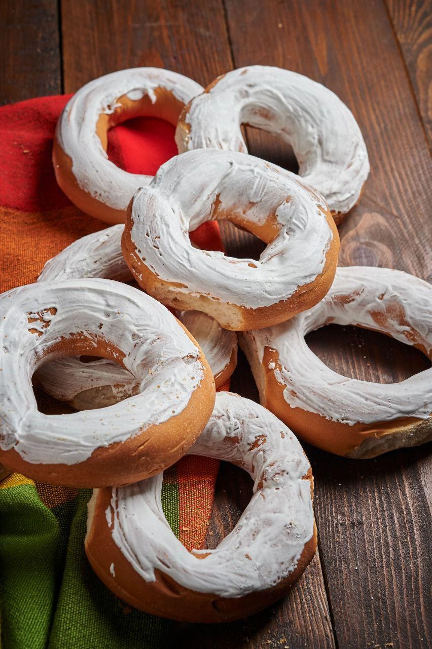 Donas cubiertas con glaseado blanco sobre mesa de madera
